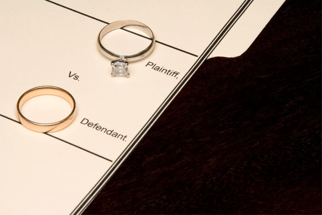 two wedding rings on a document that reads "plaintiff vs defendant"