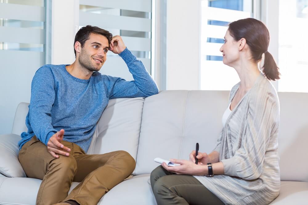 man talking to woman at Therapy