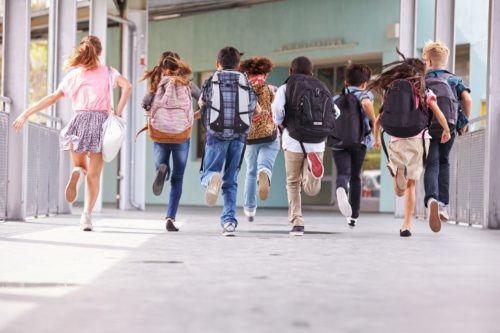 group of kids running into school
