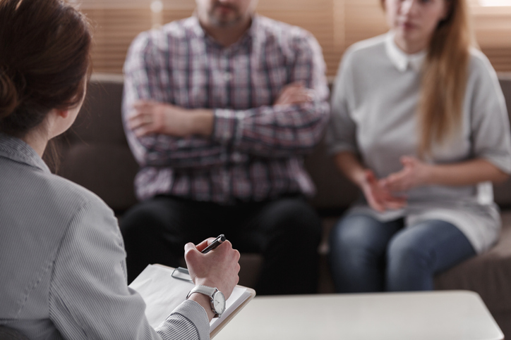 couple at therapy, and the therapist writing