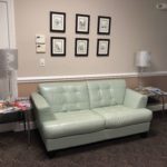 white sofa next to a pink wall with pictures in office of Marietta 