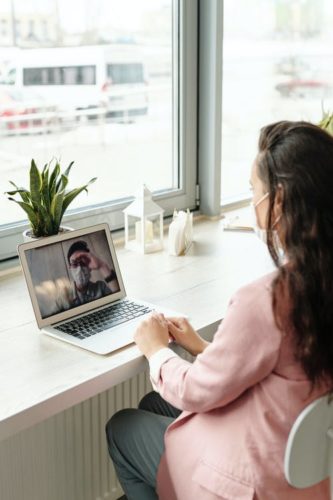 man on a screen video chatting with a woman on a desk