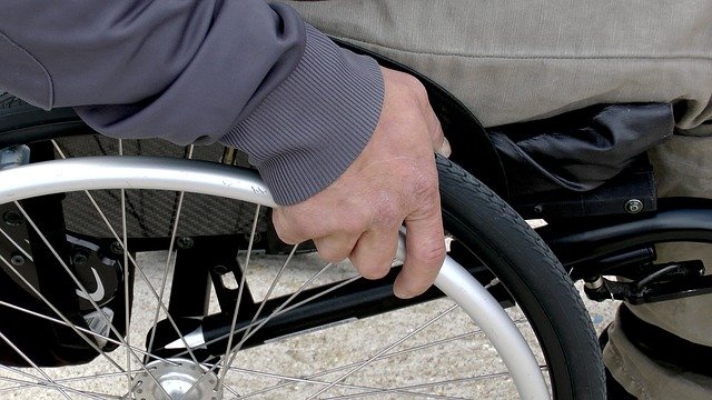hand resting on the wheel of a wheelchair