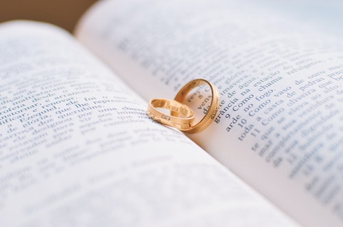 two gold rings resting in the middle of an open book