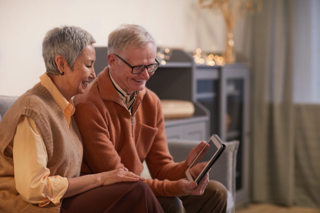 mature couple looking at an iPad together and smiling