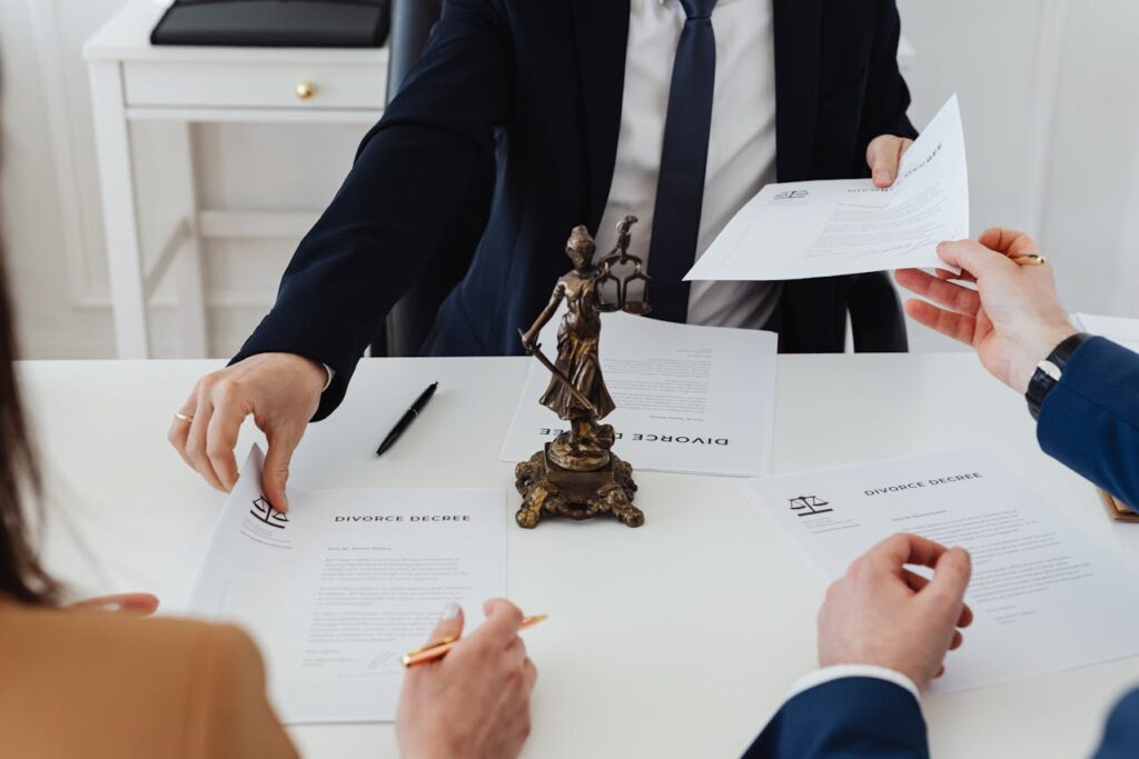 Body of lawyer in suit presenting divorce documents for couple to sign